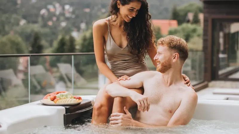 Couple relaxing in a hot tub on a terrace